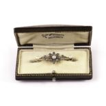 A pretty Edwardian period diamond and pearl brooch, the bar brooch centred with a flower head and