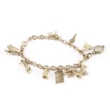 A 9ct gold charm bracelet, the curb link chain mounted with several charms such as a pussy cat,