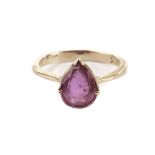 A ruby solitaire dress ring, the teardrop shaped red stone in a yellow metal mount marked 18k