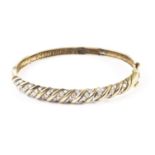 A 9ct gold and diamond bangle, one half of the hoop with rope twist design set with columns of