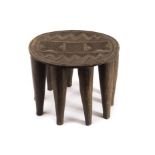 Of African tribal interest: A hardwood carved table or stool, the circular top with engraved designs