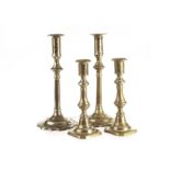 A pair of Georgian brass candlesticks, with scalloped edge base and rims to sconces, together with a