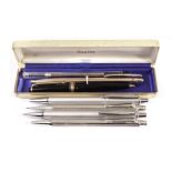 A group of six pens and pencils, including a Mont Blanc retractable pencil, a Caran d’Ache biro with