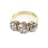 An impressive three stone diamond engagement ring, the old cuts in white metal claws on an 18ct gold