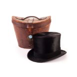 A plush silk top hat, approx. size 7, presented in brown leather hat box with locking clasp (2)
