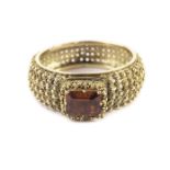 An antique gold and hessonite dress ring, the rectangular orange coloured stone in an ornate