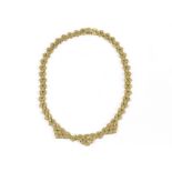 A French gold fringe necklace, made up of stylised engraved yellow and rose coloured textured links,