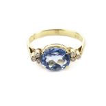 A modern gem set dress ring, having a bright blue oval stone, possibly a topaz, and two sets of