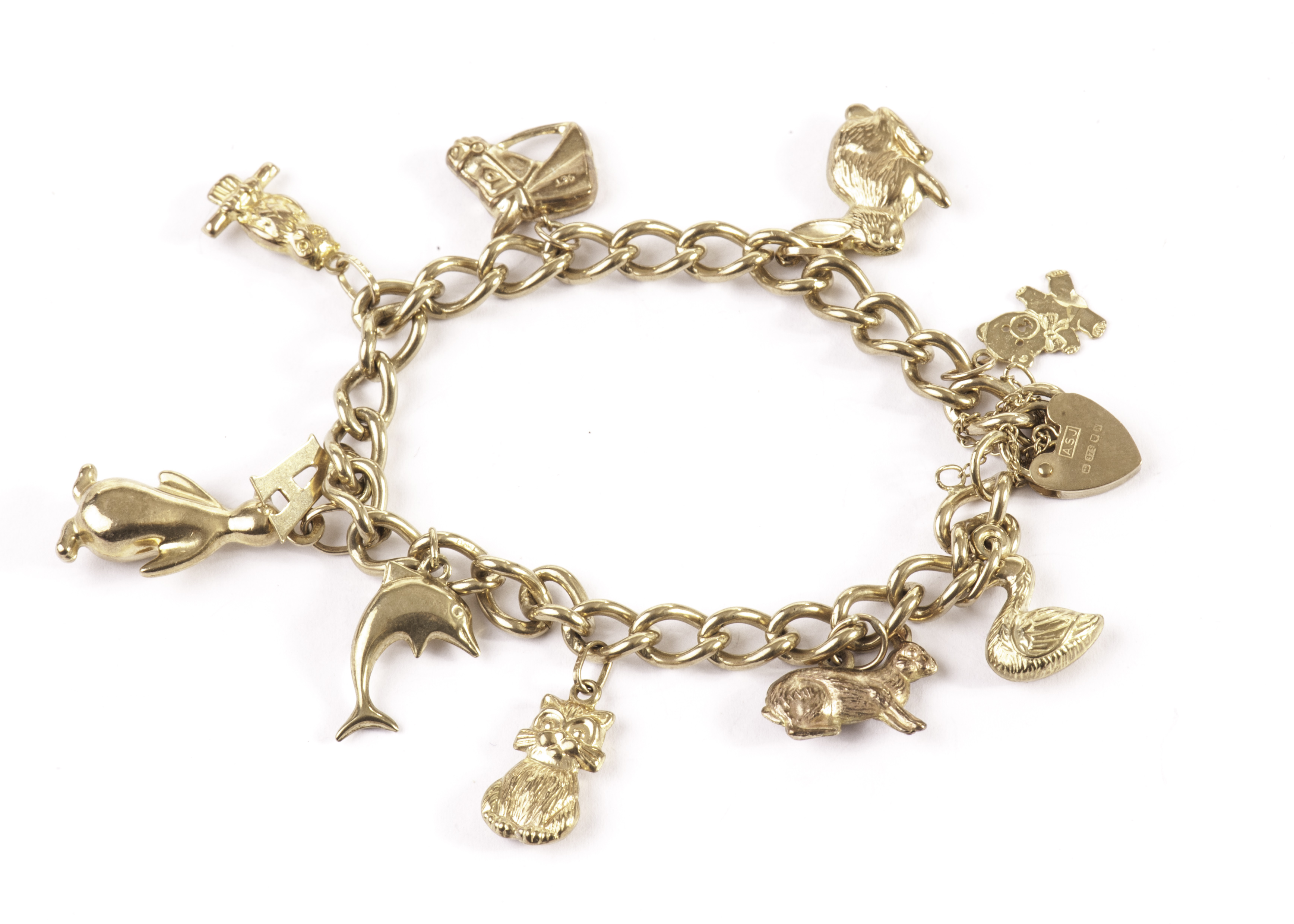A 9ct gold charm bracelet, the curb link chain united by a heart shaped clasp and supporting