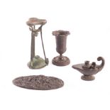 A collection of four Grand Tour relics, including an urn, an oval plaque, an oil lamp and a tripod