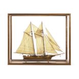 A scratch-built twin masted small Clipper style boat, constructed of wood with a varnish finish,