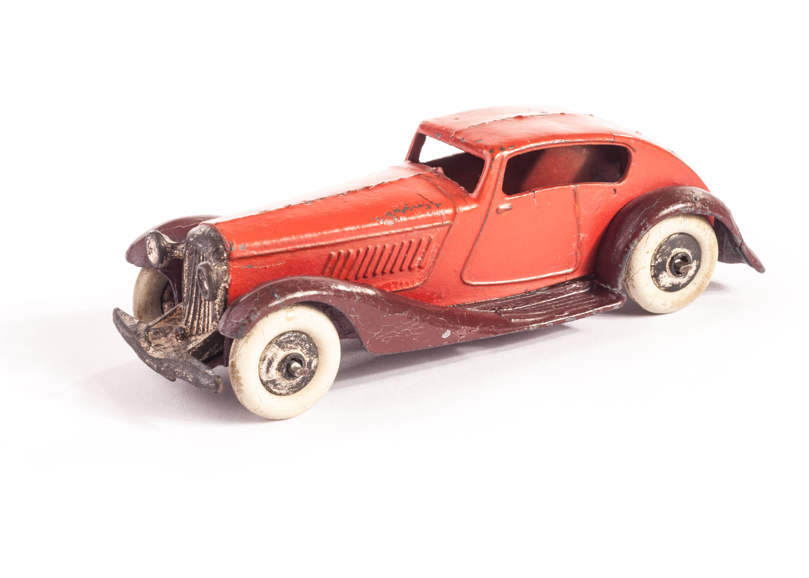 A Pre-War Dinky Toys 24e Super Streamlined Saloon, red body, criss-cross maroon chassis, plated ‘