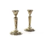 A pair of silver dwarf candlesticks, hallmarked for London 1920, and with the maker's mark JE in a
