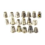A collection of silver and white metal thimbles, each having various design, some with enamel