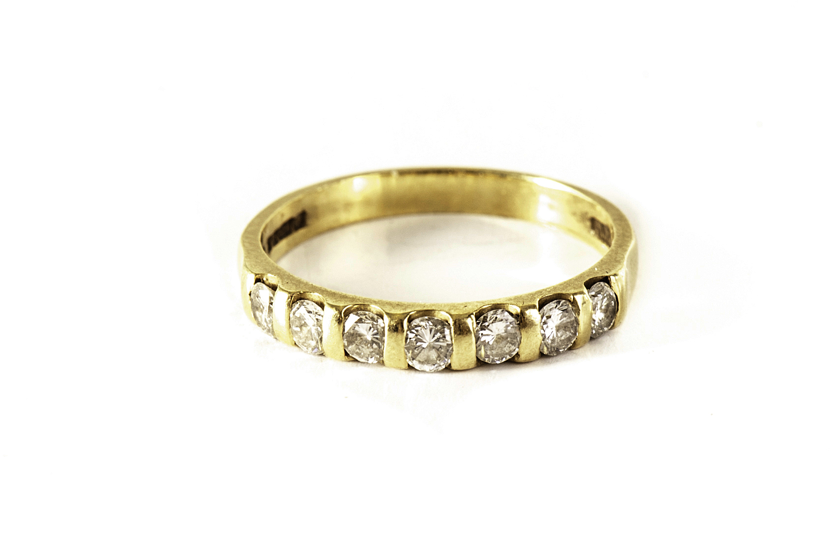An 18ct gold half eternity ring, having seven brilliant cut stones to top, possibly diamonds, size