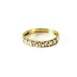 An 18ct gold half eternity ring, having seven brilliant cut stones to top, possibly diamonds, size