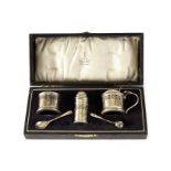 A George V silver cruet set, marked Birmingham, having blue glass liners, in fitted box