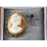 An antique gold and ruby stick pin, together with a yellow metal shell cameo brooch (2)
