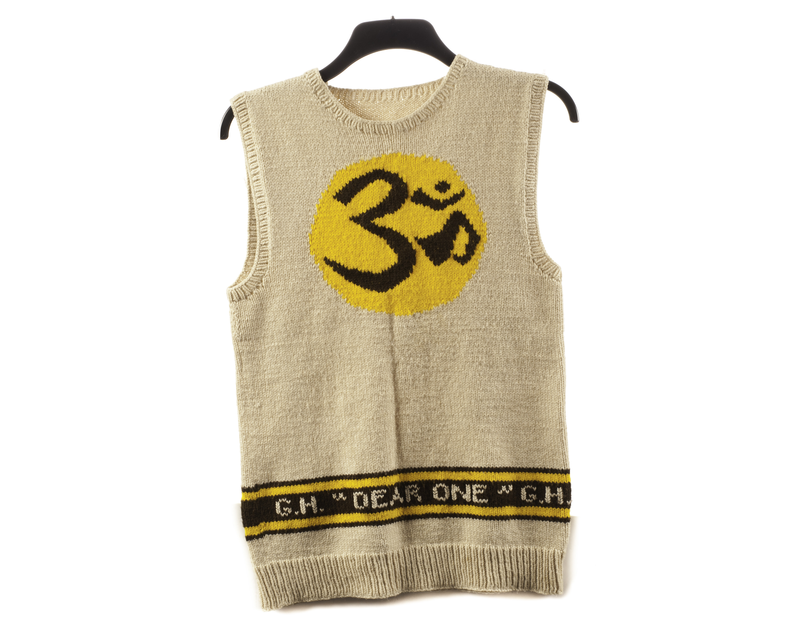 The Beatles / George Harrison: A hand knitted sleeveless jumper with 'OM' logo, this jumper the