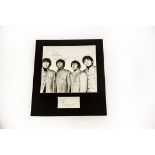 The Beatles / Autographs: A mounted black and white print of The Beatles signed with dedication to