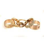 A selection of five 9ct gold rings, four having gem set design, the other with engraved floral