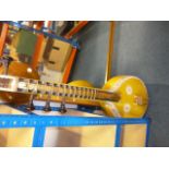 A saraswati veena sitar, painted yellow with dragon head design to top