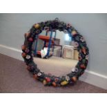 A plaster encrusted circular wall mirror, having fruit amongst foliate decoration, AF