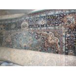 A pale blue ground Eastern style carpet, with central floral medallion and multi-border, approx