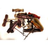 A large collection of vintage and modern wooden handled corkscrews, all of similar design, some with
