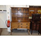 An Arts and Crafts oak dresser, the upper section with two shelves and a central compartment with