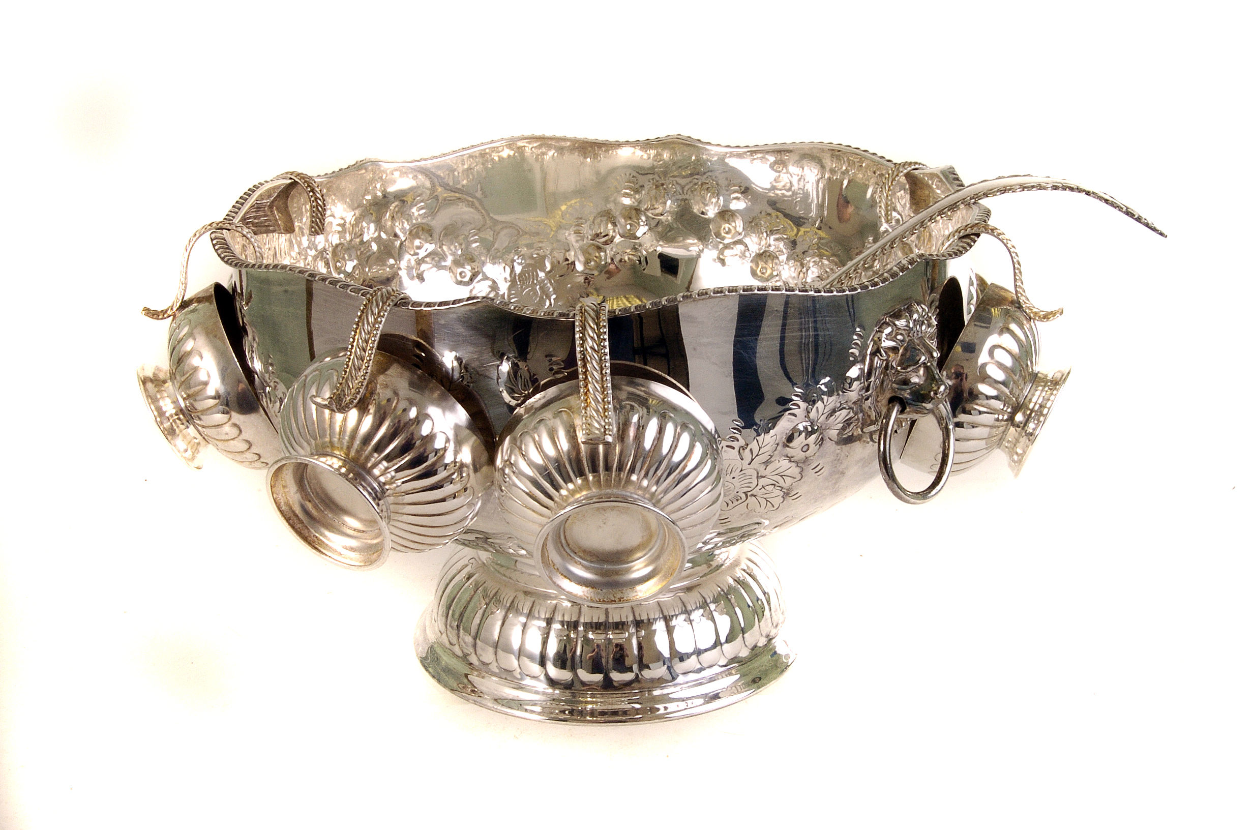 A large silver plated fruit bowl, having repousse floral design, together with cup plated cups and a