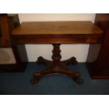 A William IV rosewood fold over pedestal card table, the lappet carved pillar surmounts a