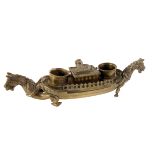 A brass inkwell, in the style of a Viking longboat, having mythological creatures to either end, AF