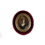 An oval portrait miniature,  depicting an elegant lady with pearl necklace and a floral headdress,