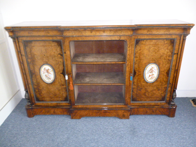 A fine Victorian burr walnut break front cabinet, the cherub painted sevres plaque inlaid doors