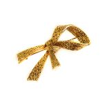 A French 18ct gold brooch from Boucheron, modelled as a tied ribbon with textured ground, marked