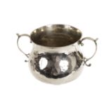 A George V silver porringer from Crichton Bros, the plain waisted vessel with apllied S shaped