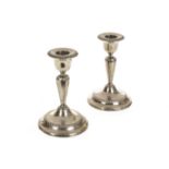 A pair of silver dwarf candlesticks, hallmarked Sheffield 1912, by Fordham & Faulkner, with loaded