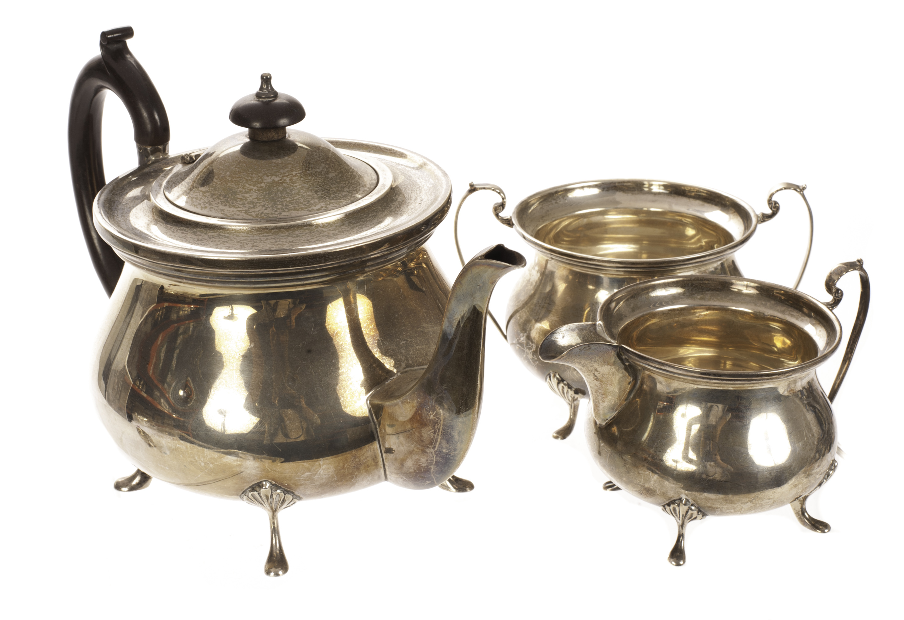 A George V silver three piece tea set by WA, the squat form vessels on four pad feet supports,
