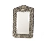 A modern white metal framed mirror, the ornate border with scrolling foliage, bearing traces of