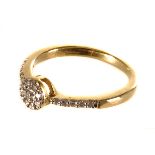 A 9ct gold diamond ring, the circular tablet top mounted with multiple round cut diamonds, flanked