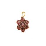 A 9ct gold pink tourmaline and diamond pendant, the seven oval cut pink stones forming a floral