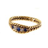 An 18ct marked sapphire and diamond ring,  rope twist design centre with three sapphires and two old