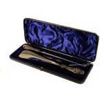 A silver handled button hook and shoe horn set, presented in a black leatherette case with three