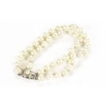 A pearl bracelet, possibly once a double strand pearl necklace, with silver and pearl mounted clasp,