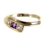 A 9ct gold and gem set crossover style ring, the white gold mount supporting two CZs and an