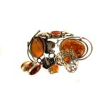 Five items of white metal and Baltic amber jewellery, including a pierced silver brooch, a pair of