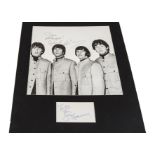 The Beatles/ Autographs: A mounted black and white print of The Beatles signed with dedication to