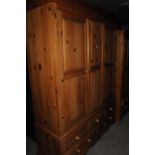 A Pinecraft triple wardrobe, with fixed centre panel above a five drawer base 162.5cm W x 210.5cm H