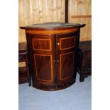 A George III mahogany and inlaid bow front corner cabinet, with three small drawers and two dummy